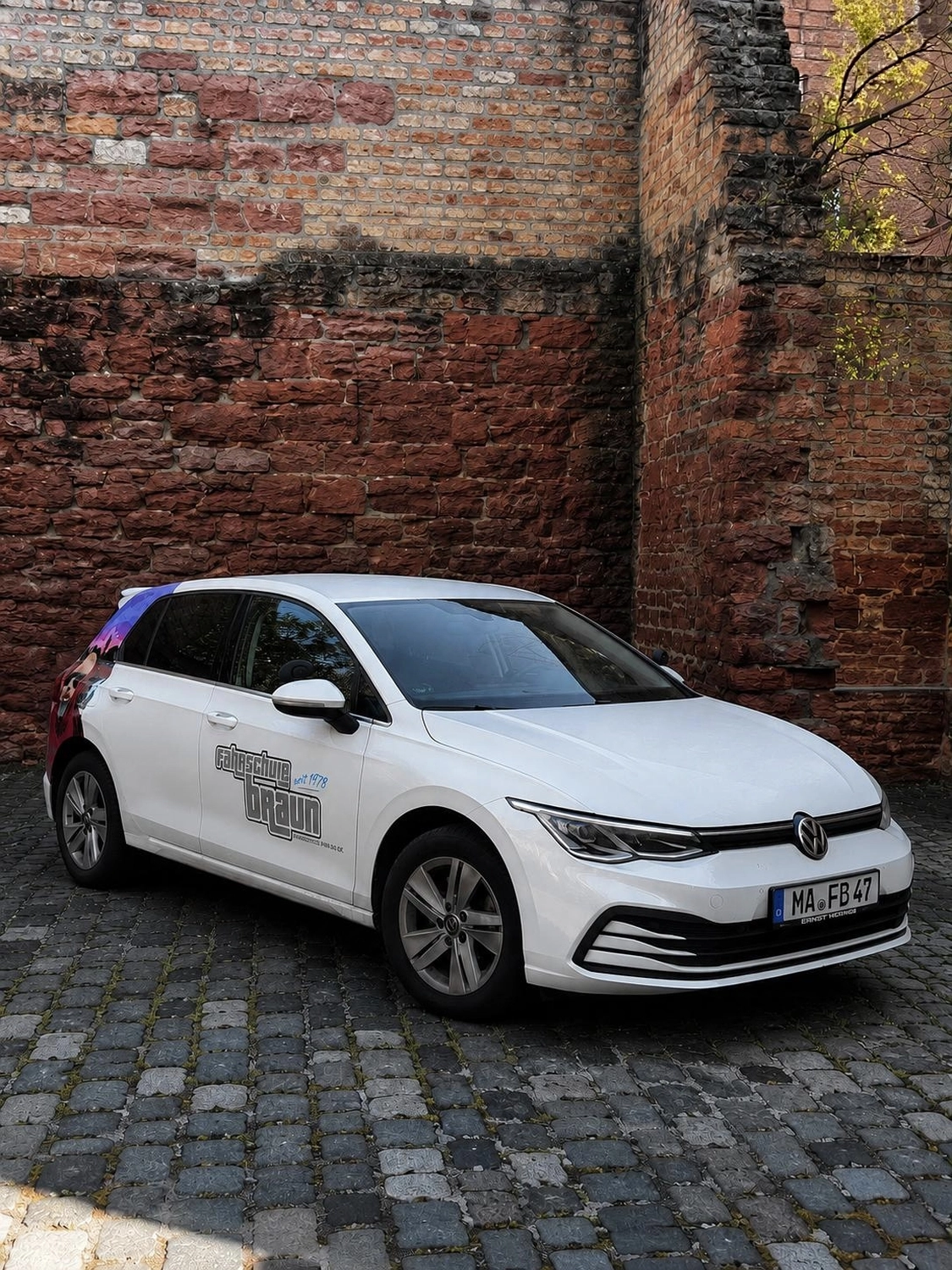 Weißer VW Golf der Fahrschule Braun mit Fahrschulbeschriftung