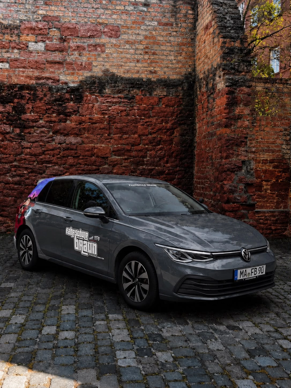 Grauer VW Golf der Fahrschule Braun mit Fahrschulbeschriftung